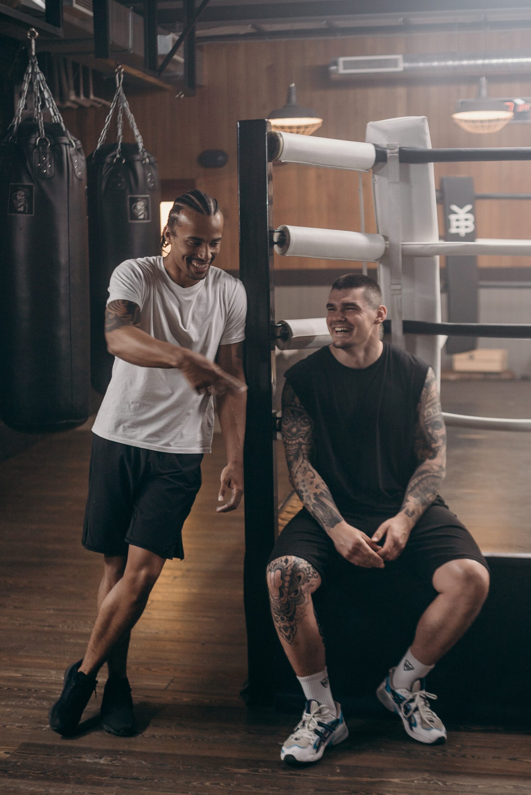 Men smiling and having a conversation in a boxing ring